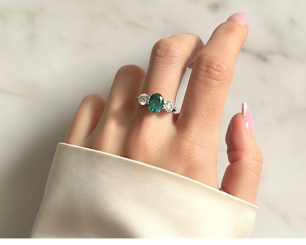 vintage style emerald and diamond three stone ring in platinum for sale in Leeds, Uk, on model's hand