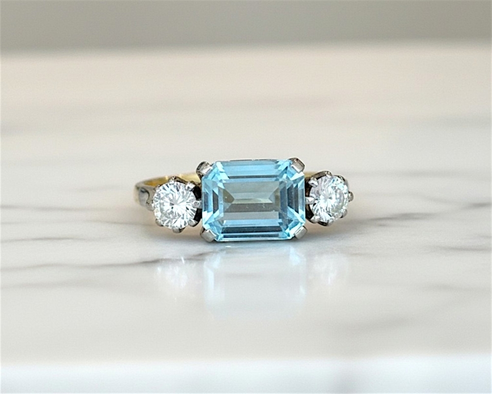 Art Deco aquamarine and diamond ring set with an emerald cut aquamarine and two round diamonds in 18ct yellow gold and platinum. For sale in Leeds, UK