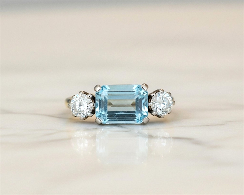 Art Deco aquamarine and diamond ring set with an emerald cut aquamarine and two round diamonds in 18ct yellow gold and platinum. For sale in Leeds, UK