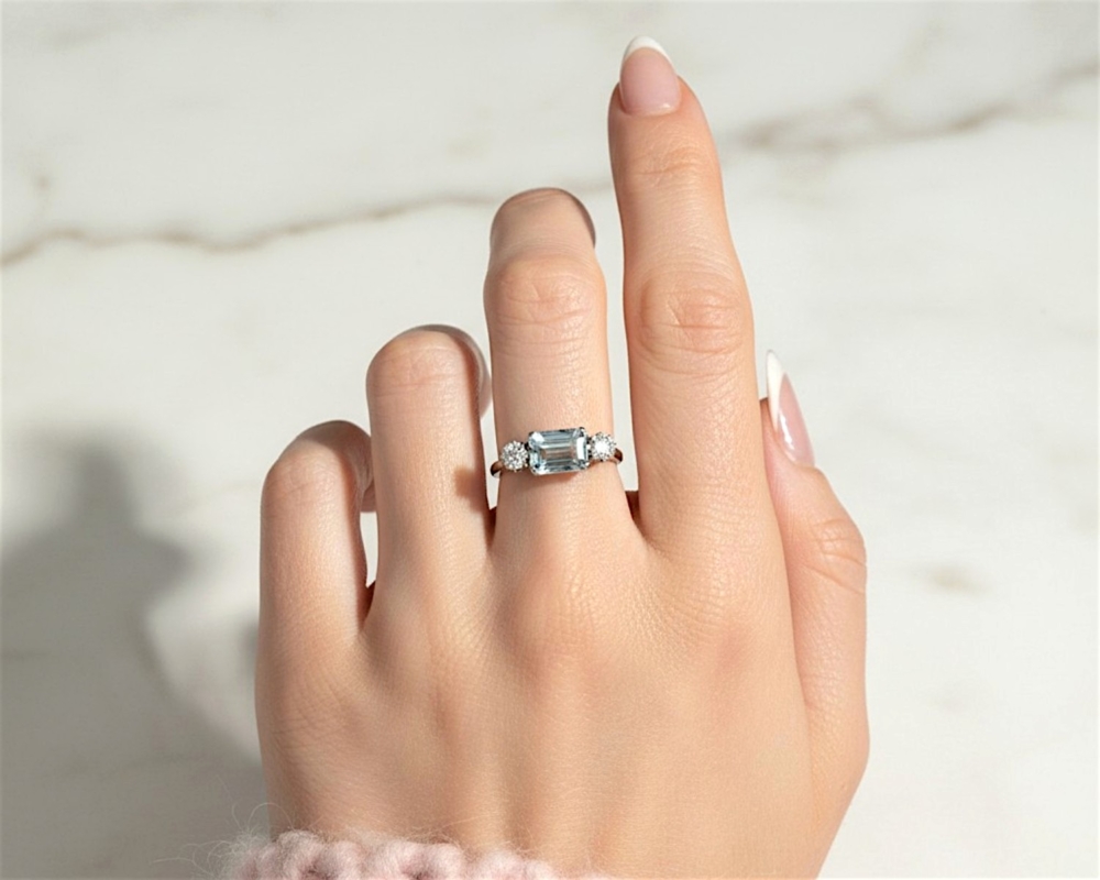 Art Deco aquamarine and diamond ring set with an emerald cut aquamarine and two round diamonds in 18ct yellow gold and platinum. For sale in Leeds, UK, shown on model's hand