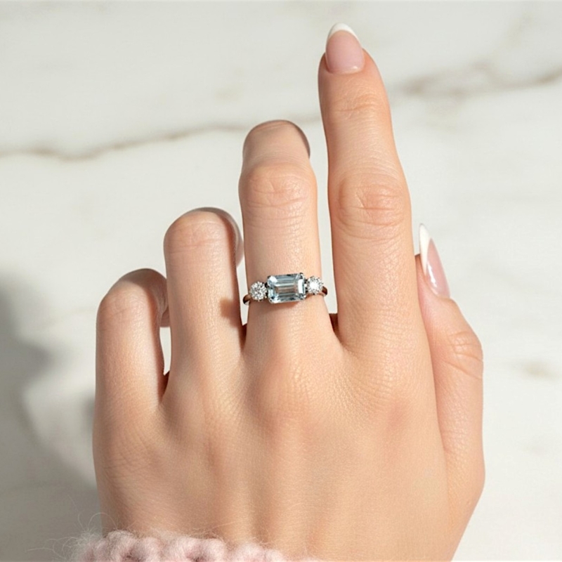 Art Deco aquamarine and diamond ring set with an emerald cut aquamarine and two round diamonds in 18ct yellow gold and platinum. For sale in Leeds, UK, shown on model's hand