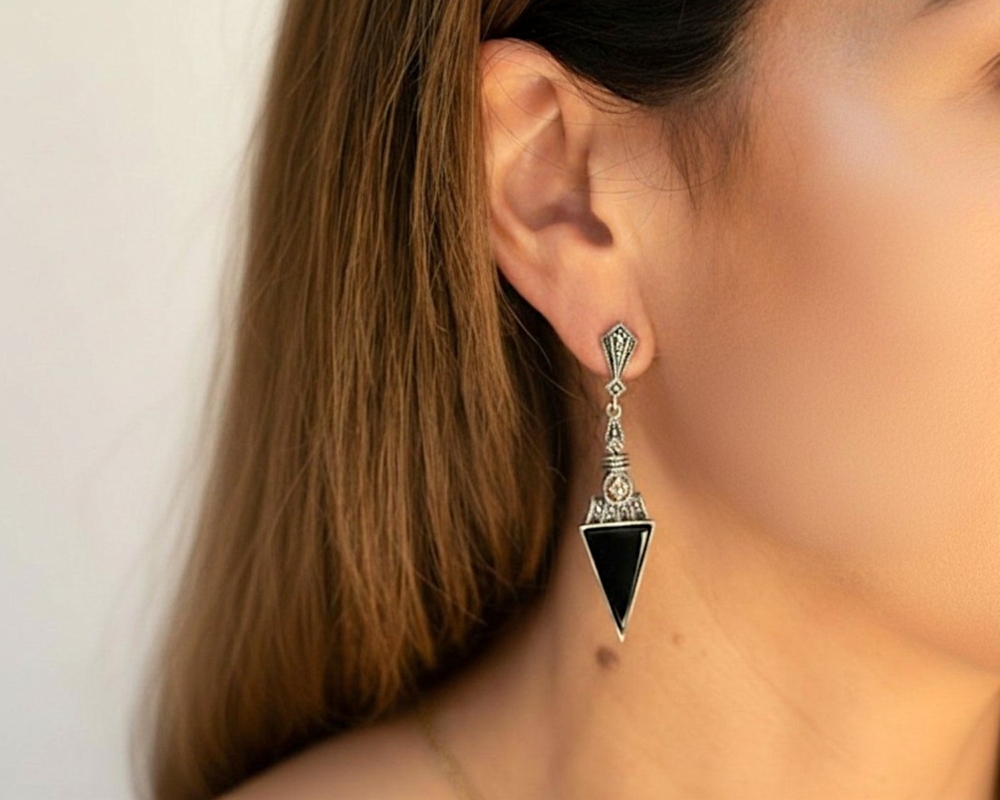 art deco style onyx statement earrings for pierced ears, set with silver and marcasite, shown in a model's ear