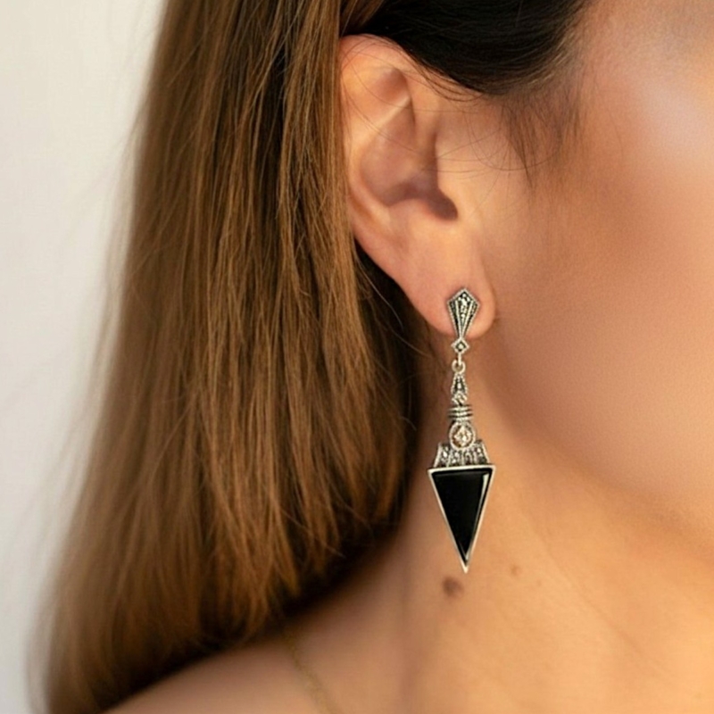 art deco style onyx statement earrings for pierced ears, set with silver and marcasite, shown in a model's ear