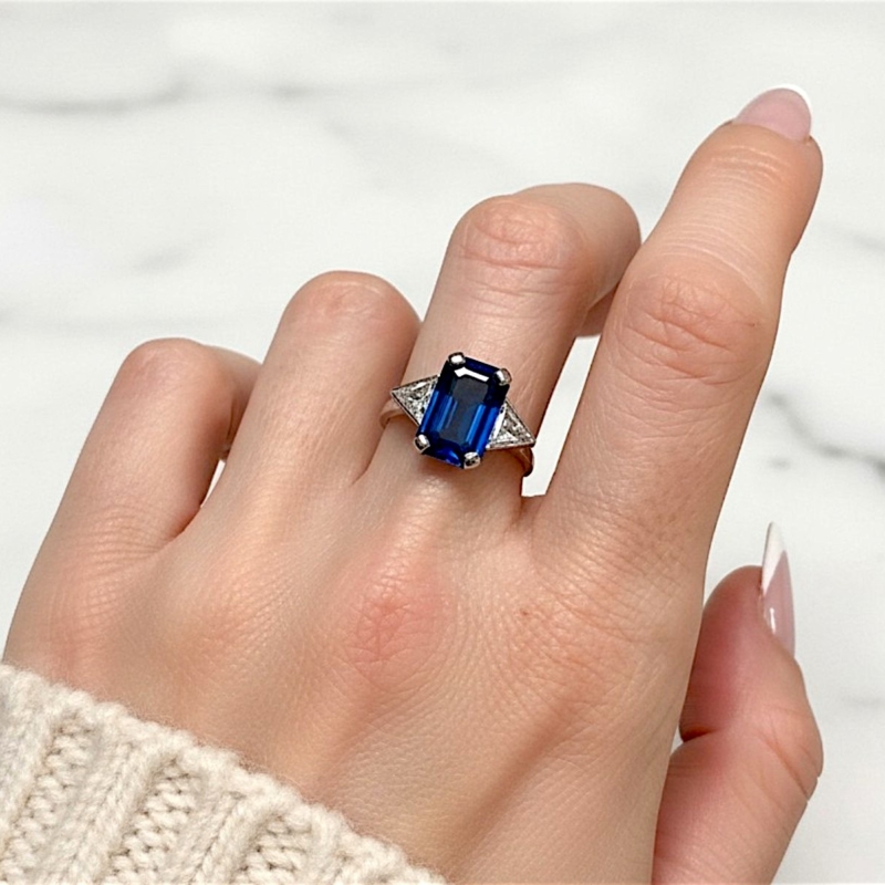 Art deco style sapphire and diamond ring with kite diamonds in 18ct white gold. Approx 5ct sapphire and 1ct diamond for sale in Leeds, shown on model's hand