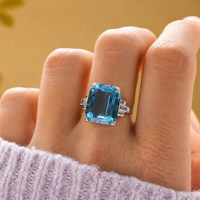 Art Deco aquamarine ring with baguette diamond shoulders for sale in Leeds. Shown here on a model's hand
