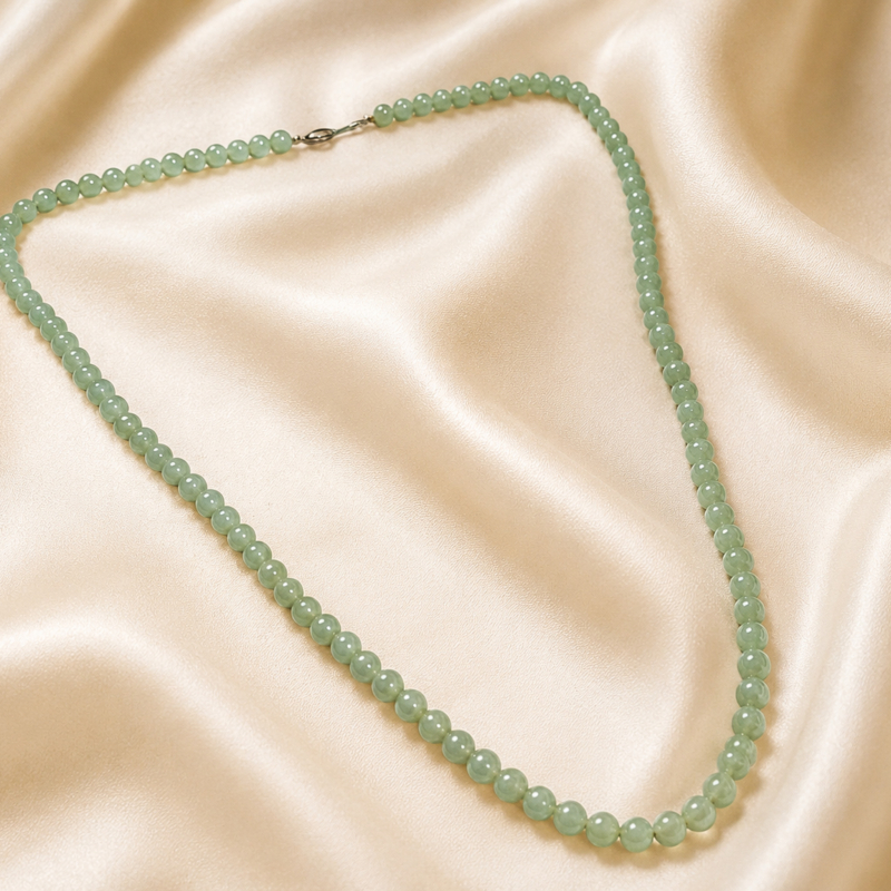 antique 1920s jade beads laying on silk, for sale in Leeds