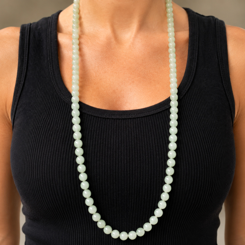 antique 1920s jade beads laying on silk, for sale in Leeds shown on model's neck