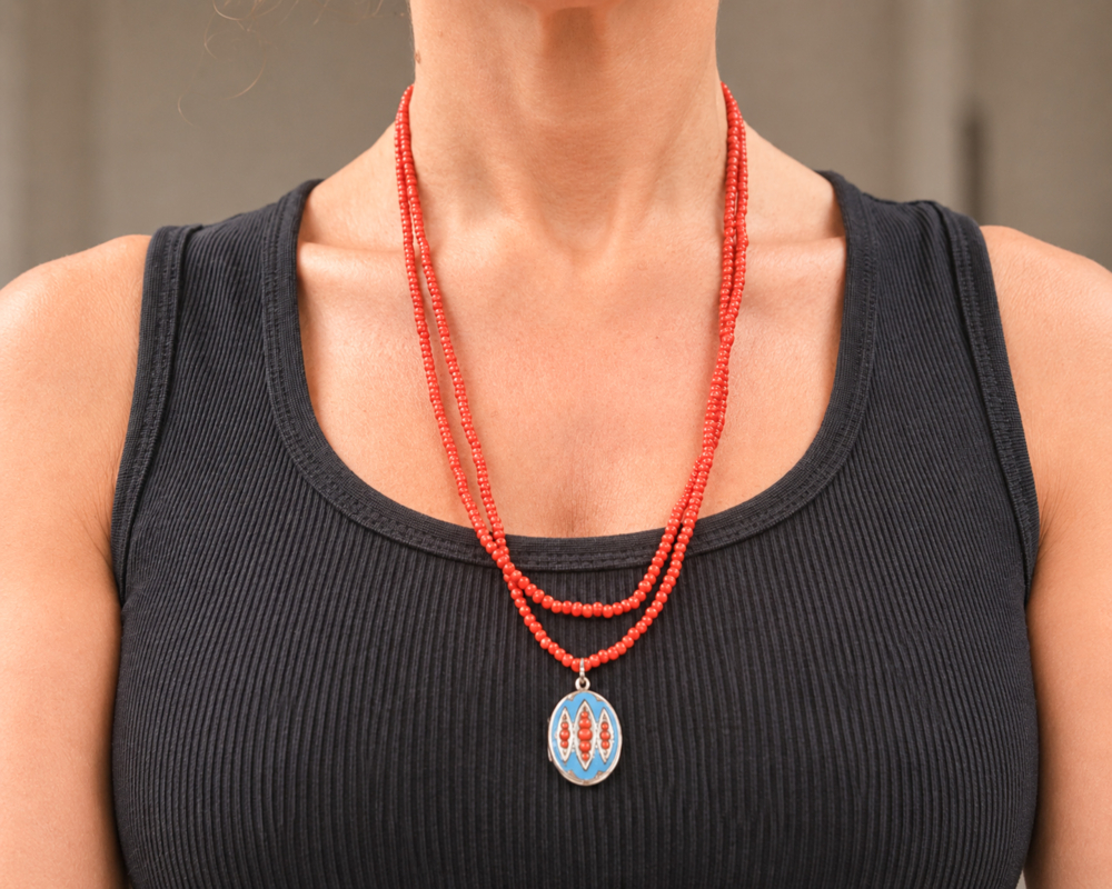 Victorian coral beads with enamel locket for sale in Leeds, shown on model