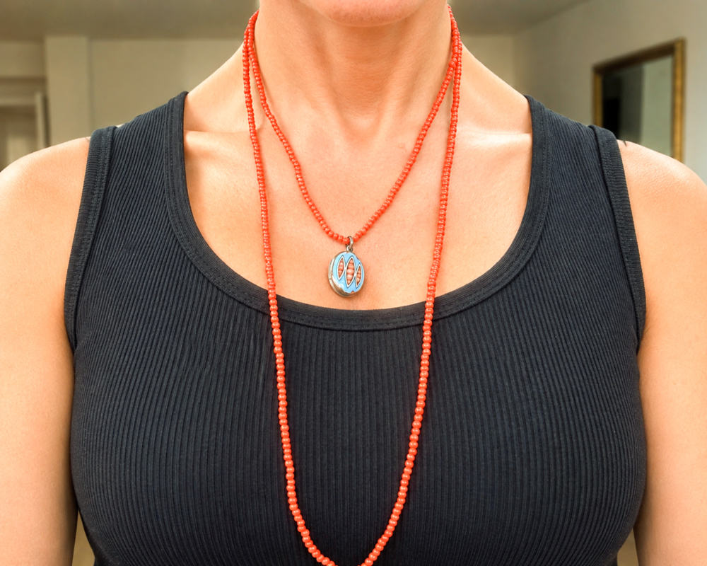 Victorian coral beads with enamel locket for sale in Leeds, shown on model