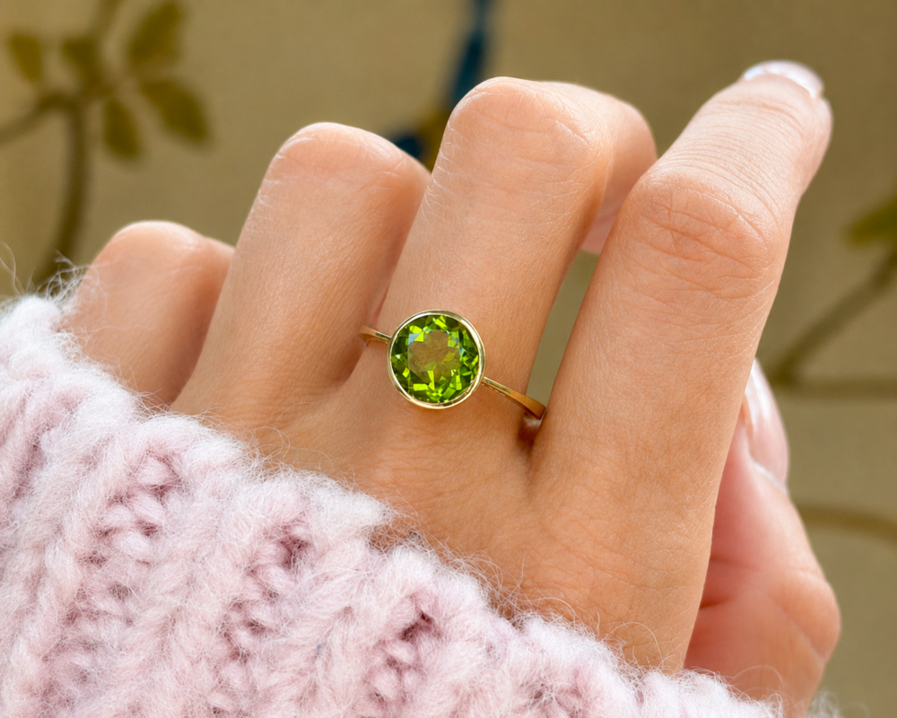 modern 9ct gold peridot ring with bezel setting for sale in Leeds, shown on model's hand