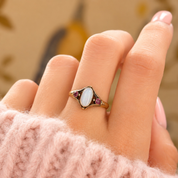 antique Victorian opal ring set with rubies in 15ct gold for sale in Leeds, shown on a woman's hand