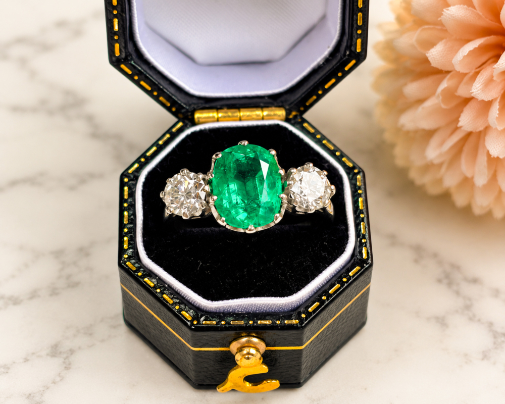 Vintage style emerald and diamond three stone ring in platinum for sale in Leeds in a black box