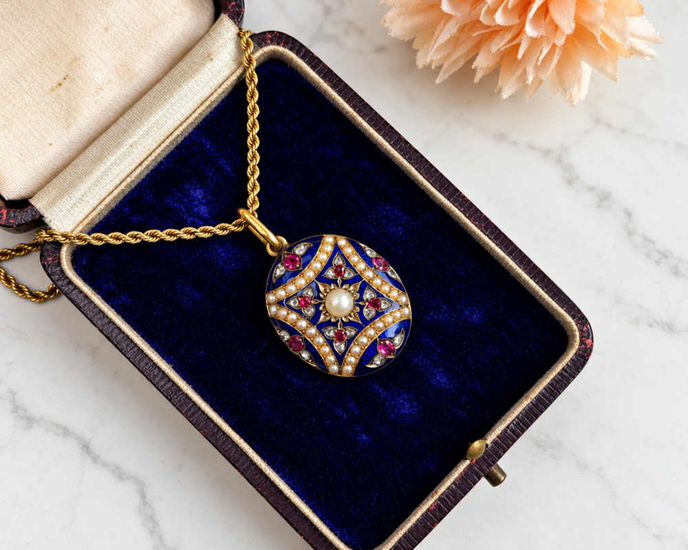 Victorian enamel open backed locket in box An antique Victorian 15ct gold blue enamel, rose cut diamond, seed pearl and ruby open backed locket on an 18ct gold 16 inch chain. Displayed in an antique box