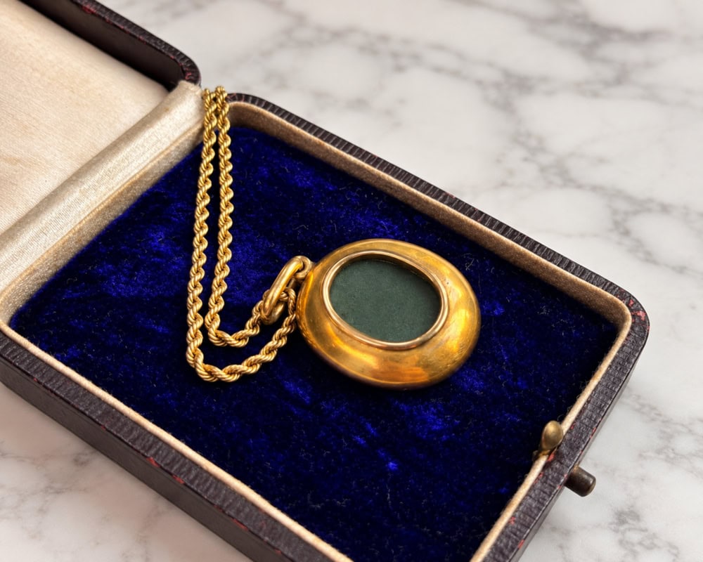 An antique Victorian 15ct gold open backed locket on an 18ct old chain, displayed in an antique box