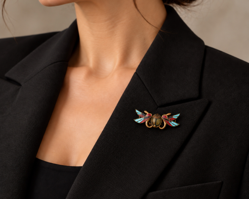 antique Egyptian Revival brooch in gilt and enamel for sale in Leeds shown on a lapel