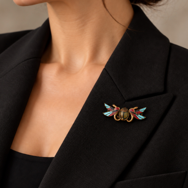 antique Egyptian Revival brooch in gilt and enamel for sale in Leeds shown on a lapel