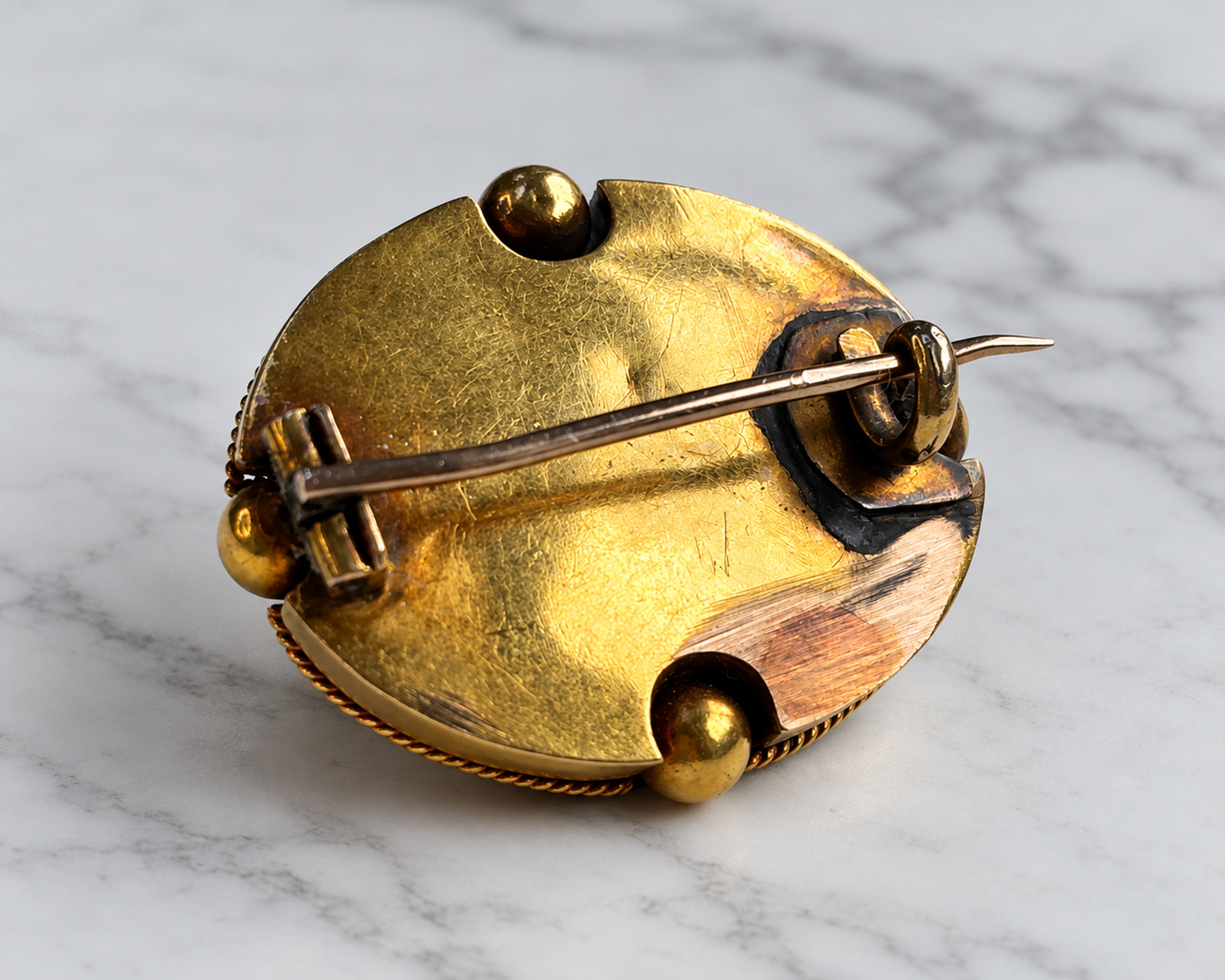 The back of a Victorian gold brooch