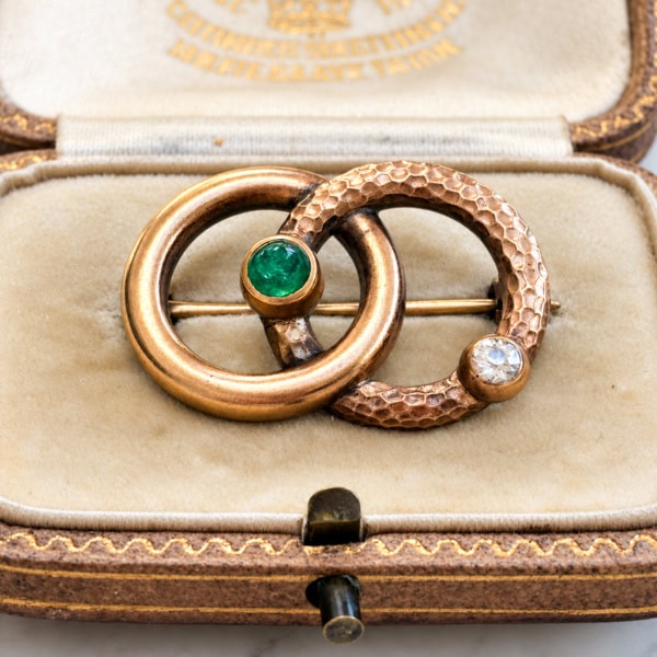 antique Victorian serpent brooch in gold with emerald and old cut diamond, displayed in an antique box