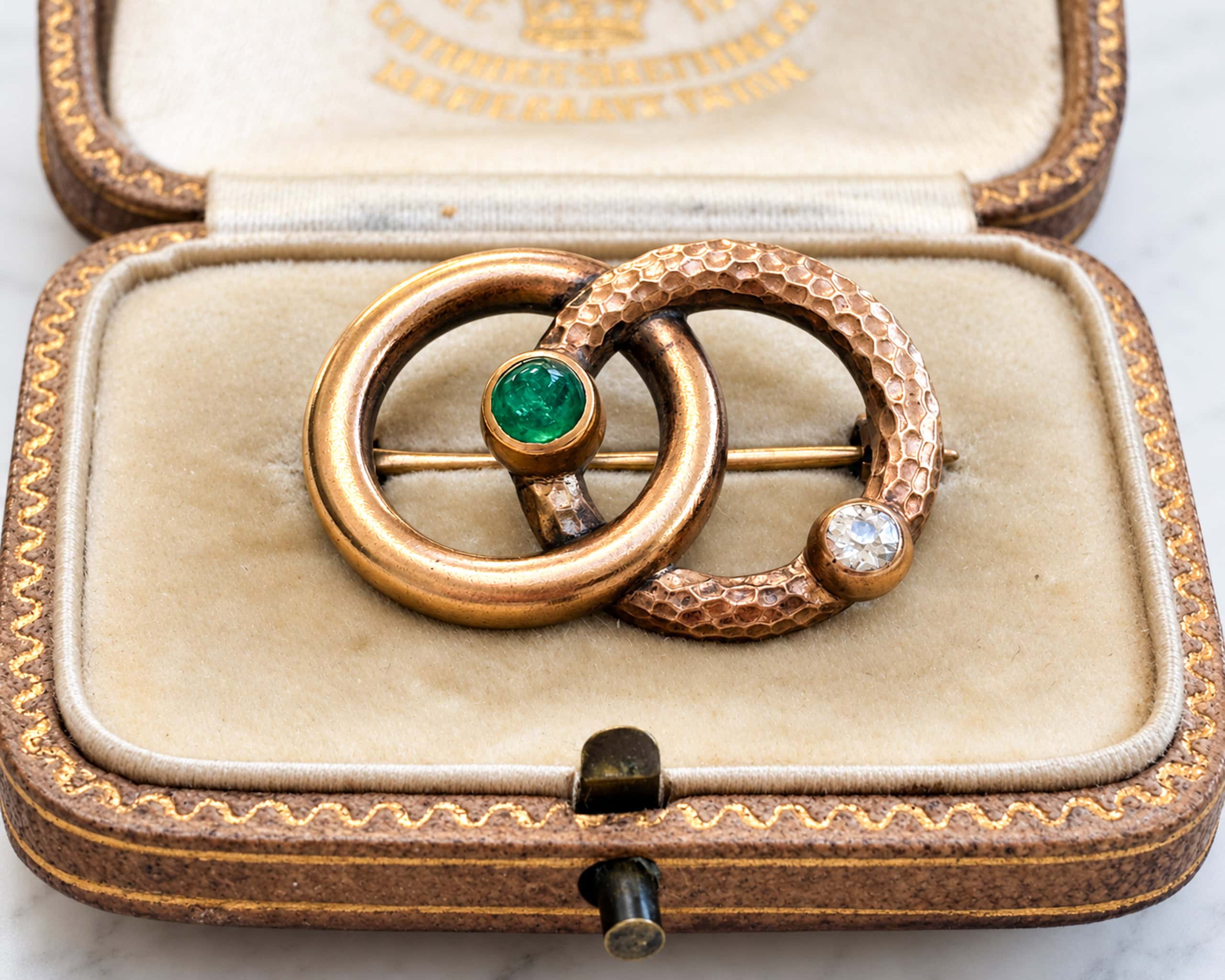 antique Victorian serpent brooch in gold with emerald and old cut diamond, displayed in an antique box
