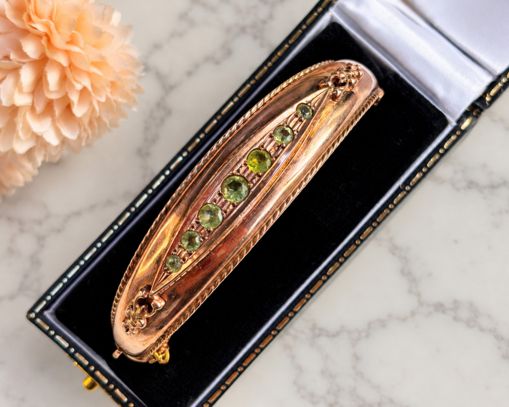 A black bangle box with a vintage 9ct rose gold peridot bangle
