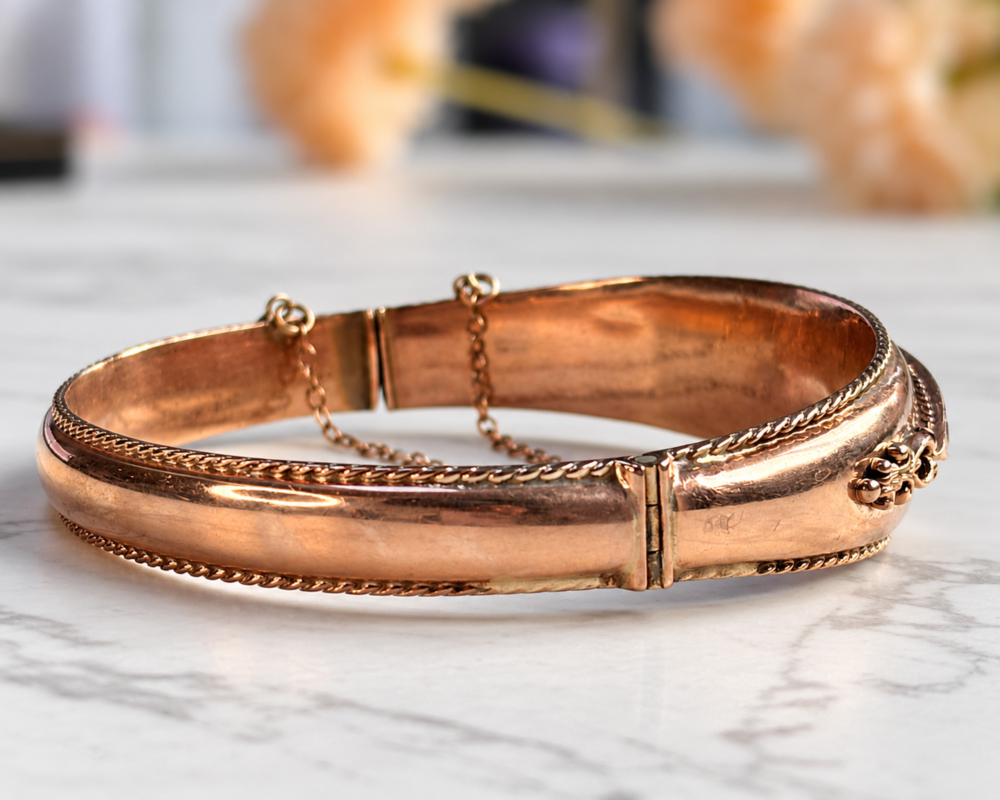 A side view of a vintage 9ct rose gold peridot bangle